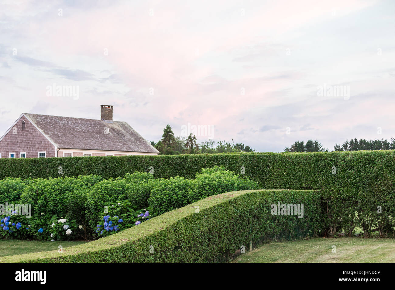 Un bellissimo cortile con perfettamente rifinito ligustro e piante fiorite in bridgehampton, NY Foto Stock