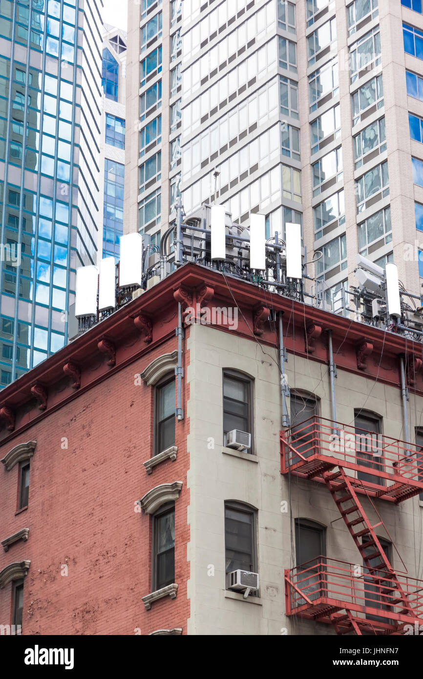 Cellulare antenne su un basso edificio ad angolo edificio appartamento attico in Midtown East New York City, NY, Stati Uniti Foto Stock