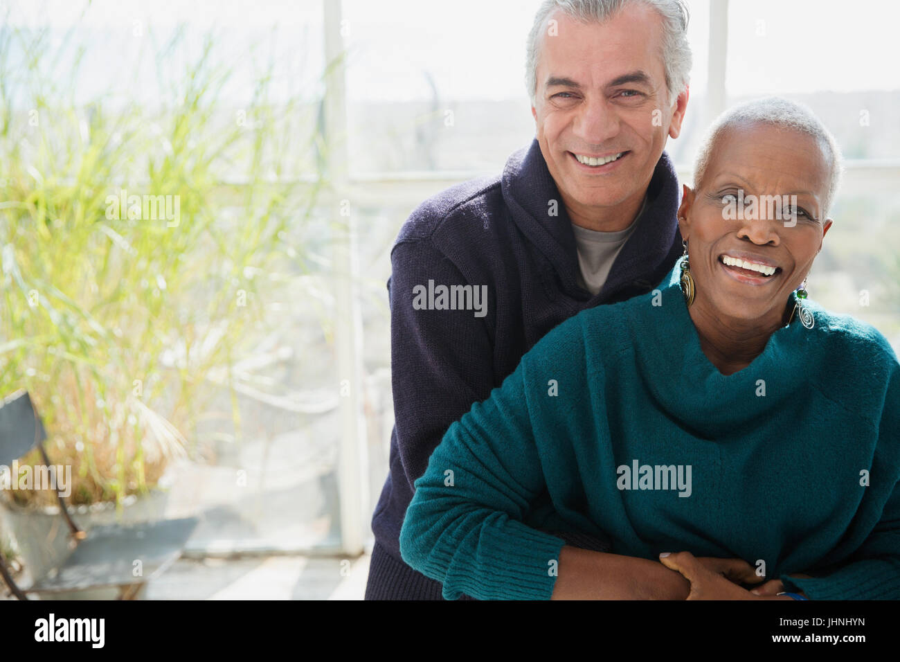 Ritratto sorridente senior giovane costeggiata sulla veranda di Sun Foto Stock