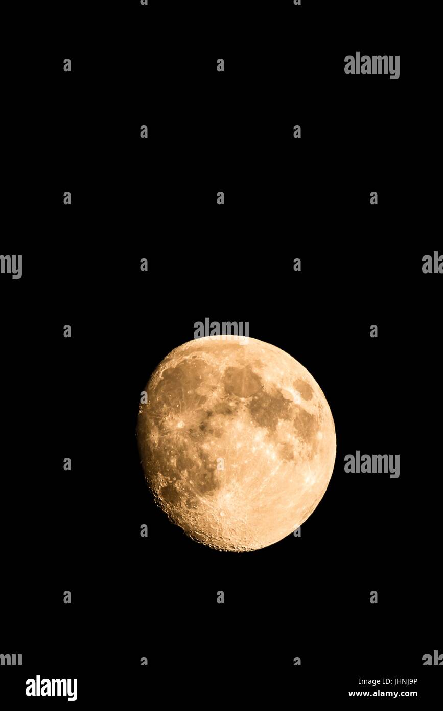 Foto verticale di Nizza golden luna con crateri visibili sul bordo dell'ombra. La luna è quasi pieno con solo piccola parte nascosti nel buio. Il li Foto Stock