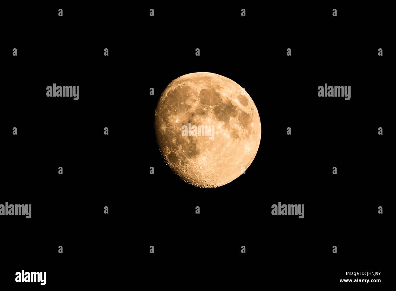 Foto orizzontale di Nizza golden luna con crateri visibili sul bordo dell'ombra. La luna è quasi pieno con solo piccola parte nascosti nel buio. Il Foto Stock