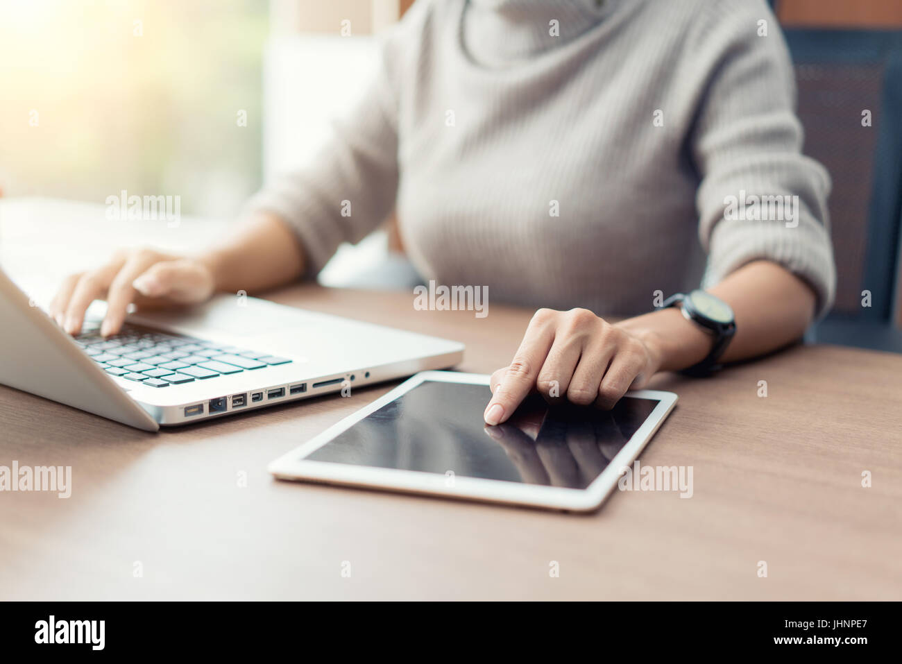Donna con notebook e tablet digitale durante il lavoro in ufficio, le mani vicino. Foto Stock