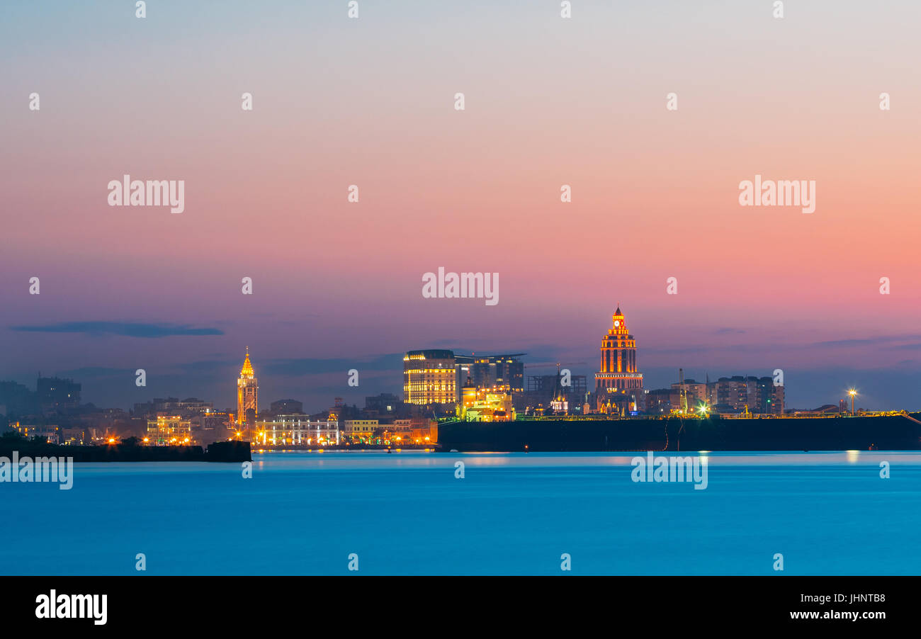 Batumi, Adjara, Georgia. Colorato luminoso cielo di sera sulla cittadina al tramonto o l'alba. Vista dal mare spiaggia di paesaggio con la moderna architettura urbana Foto Stock