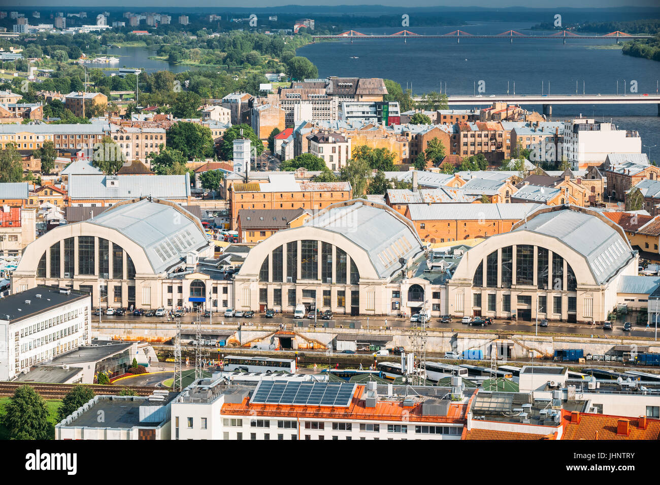 Riga, Lettonia. Paesaggio urbano dell'antenna nella soleggiata sera d'estate. Vista superiore dei punti di riferimento - Stazione degli autobus di Riga International Terminal dei Pullman e Riga Mercato Centrale Foto Stock