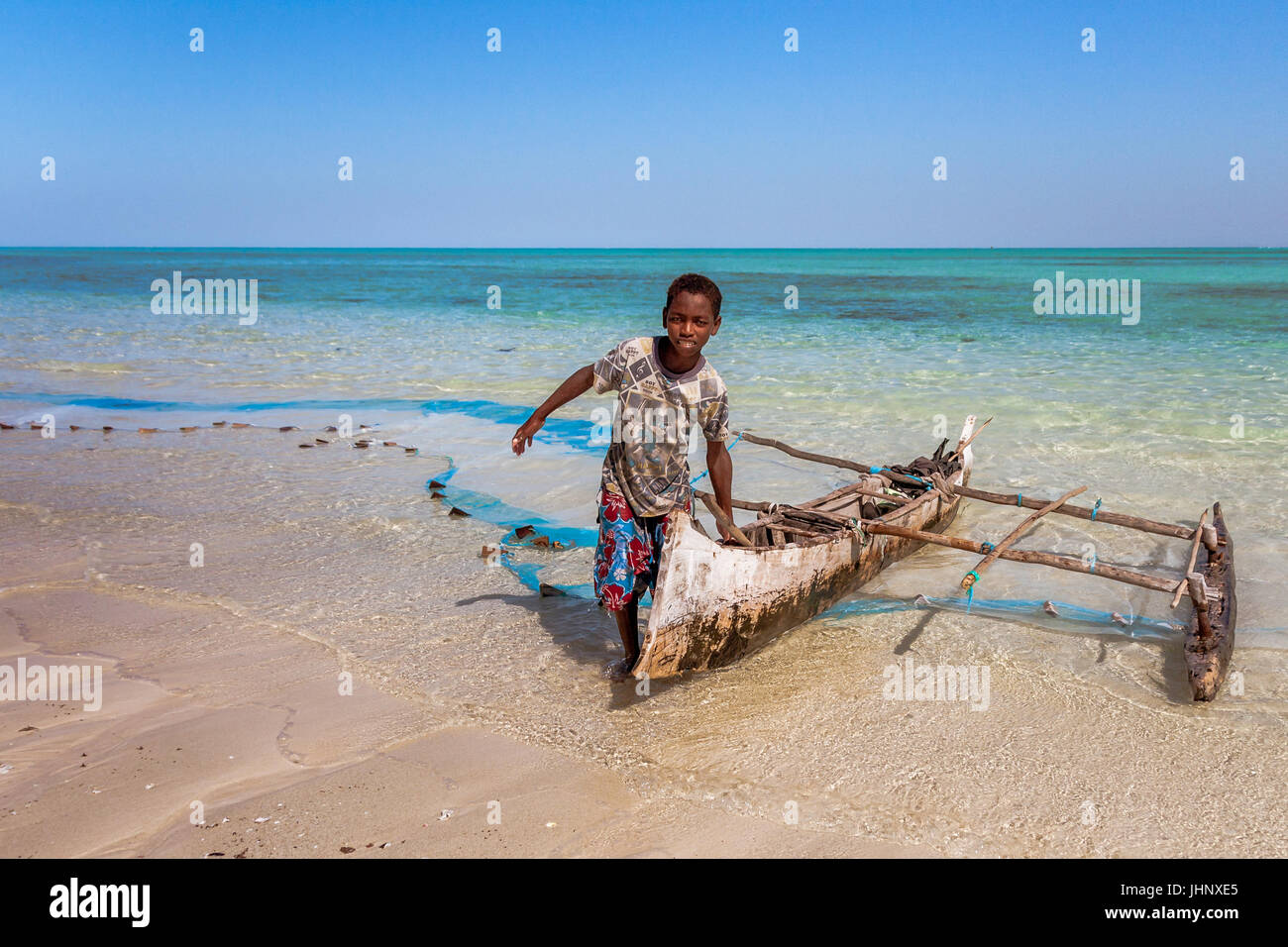 La pesca di ritorno di un giovane pescatore Vezo e la sua canoa outrigger in Tsiandamba, sud del Madagascar, il 22 luglio 2016 Foto Stock