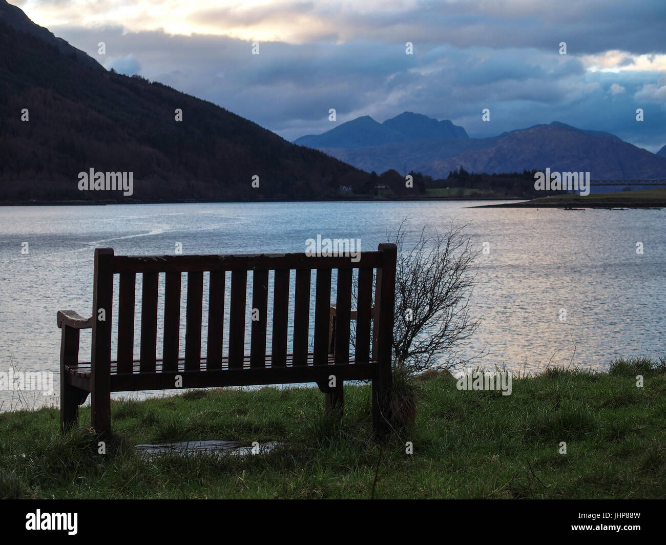 Panca e sole invernale, Loch Leven e sulle montagne circostanti Foto Stock