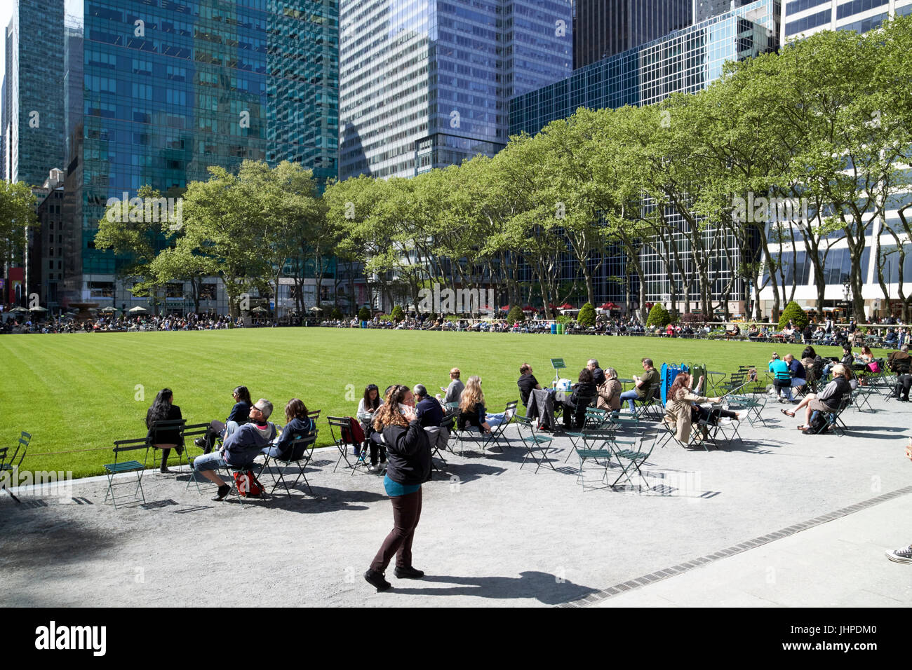 Persone mangiare il pranzo seduti in sedie in Bryant Park di New York City STATI UNITI D'AMERICA Foto Stock