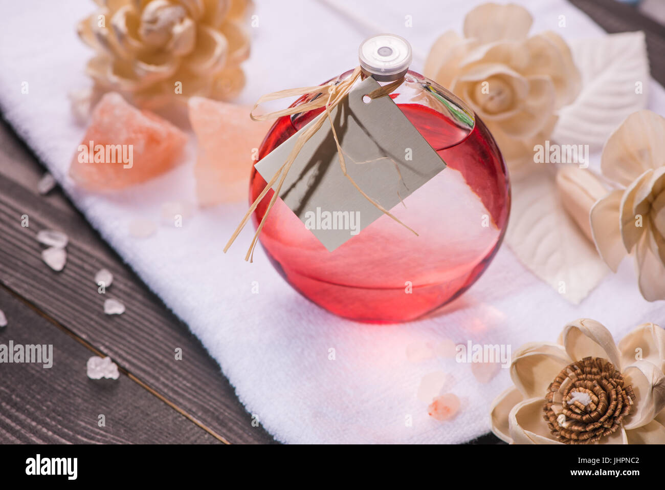 Spa decorazione. Bottiglia di olio essenziale e progetto di fiori. Foto Stock