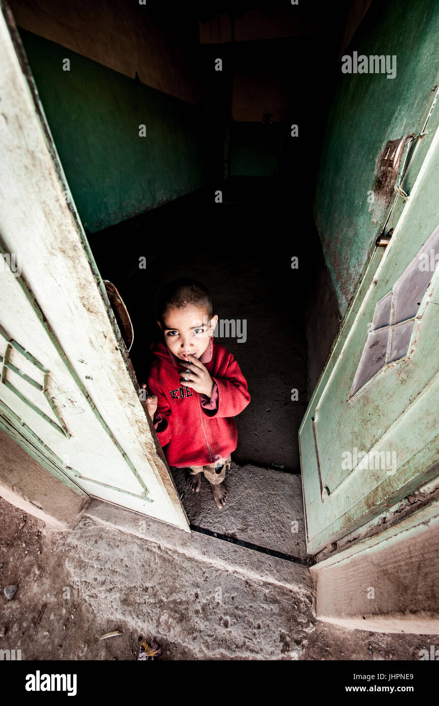 Ritratto di un ragazzino di fronte a casa sua in merzouga, Marocco Foto Stock