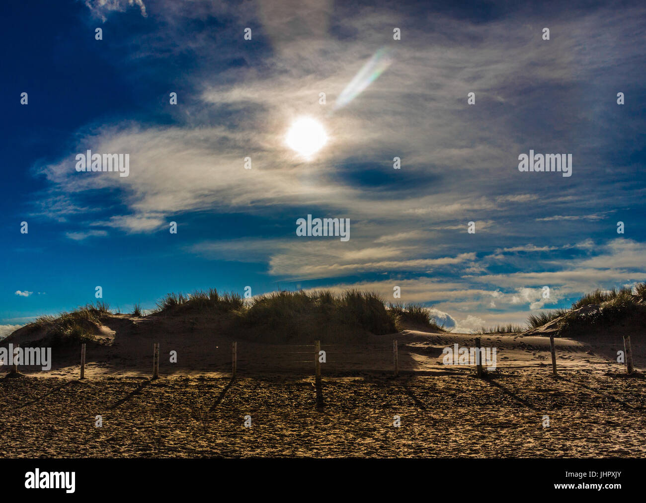 Sole che splende alto nel cielo che attraversa il Galles del nord Foto Stock