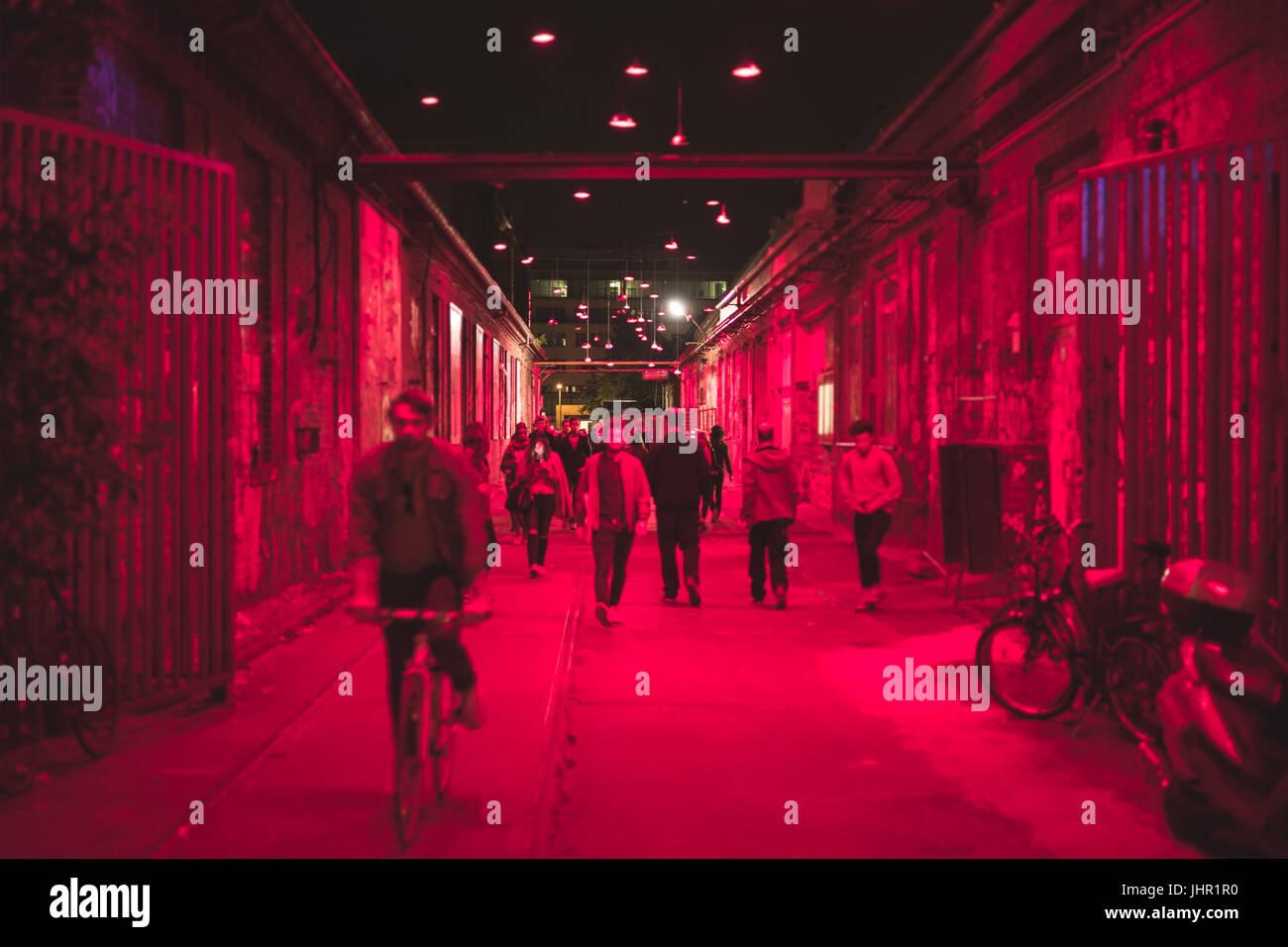 La gente camminare sulla strada di notte nella zona di vita notturna - sfocato Foto Stock