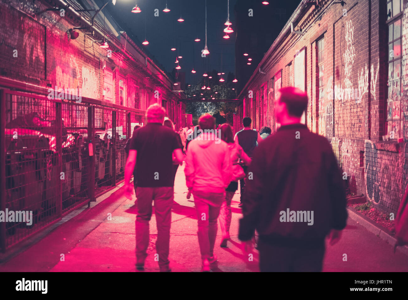 La gente camminare sulla strada di notte nella zona di vita notturna - sfocata Foto Stock