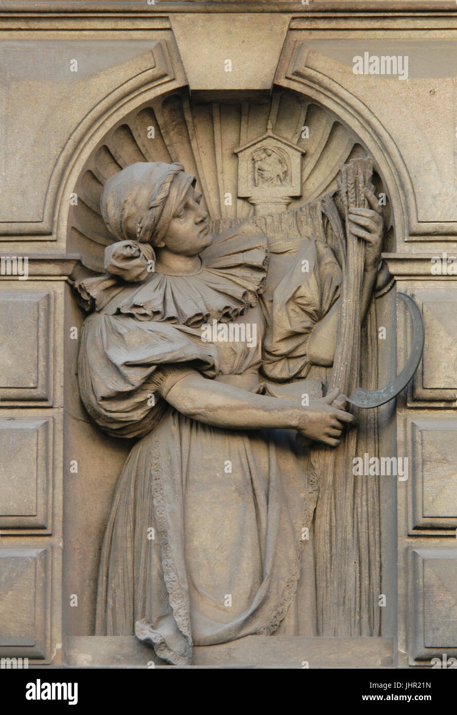 Contadina come allegoria dell'agricoltura da scultore ceco Stanislav Sucharda sulla costruzione dell'Zemská banka (Banca Zemská) in Nové město (Città Nuova) a Praga, Repubblica Ceca. L'edificio della Banca Zemská, poi utilizzato dalla Banca Živnostenská, è stato progettato da architetto ceco Osvald Polívka e costruito nel 1894-1896 in Na Příkopě Street. Foto Stock