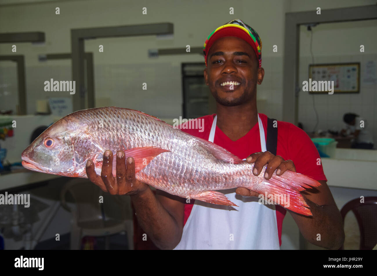 Pescatore di vendere un red snapper n il mercato del pesce di Rio Hato Foto Stock