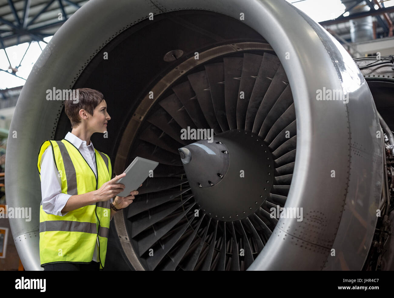Aeromobili femmina tecnico manutenzione esaminando motore a turbina di  aereo a compagnie aeree impianto di manutenzione Foto stock - Alamy
