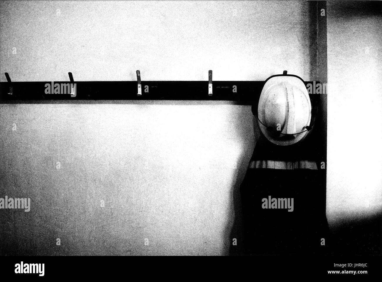 Fire fighter del mantello e casco in stazione dei vigili del fuoco a sinistra sul gancio appendiabiti dopo il ritorno da un incidente Foto Stock Fire fighter del mantello e casco in stazione dei vigili del fuoco a sinistra sul gancio appendiabiti dopo il ritorno da un incidente Foto Stock