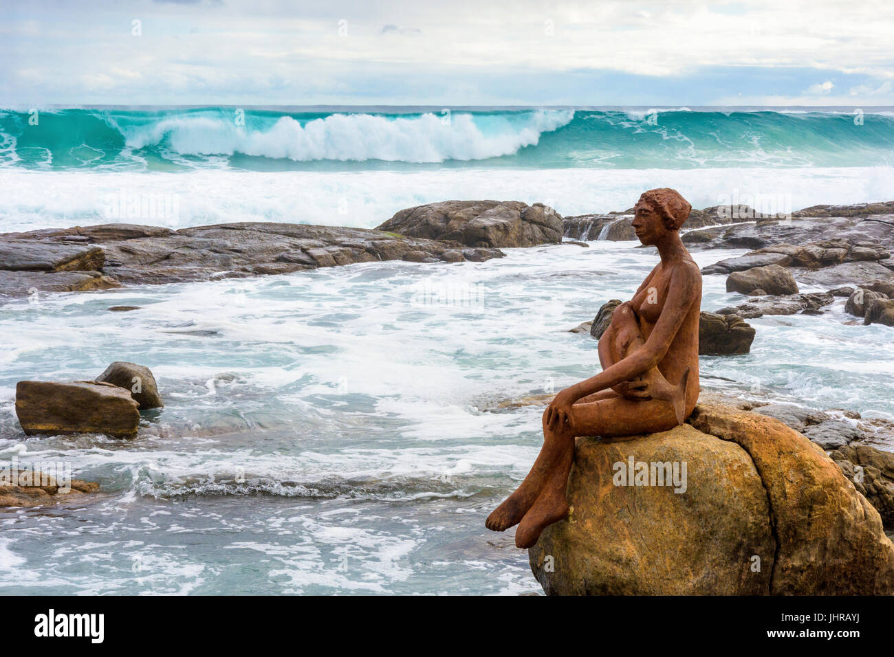 Margaret River onde da surf in rotolo verso Lucia un pubblico Arte Scultura su rocce vicino alla bocca del Fiume Margaret, Prevelly, Australia occidentale Foto Stock