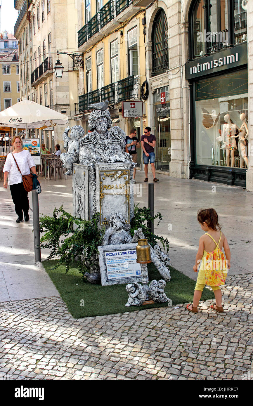 Una giovane ragazza fa una donazione a favore di un Mozart mime sulla strada Lisbona Portogallo Foto Stock