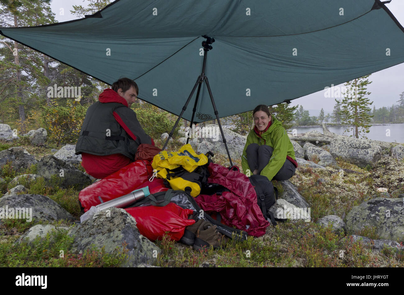 Coppia si siede sotto la pioggia sotto una tenda telone (TARP) nel lago roe, riserva naturale il ROE, Haerjedalen, Svezia, agosto 2011, Paar sitzt im Regen unter Foto Stock