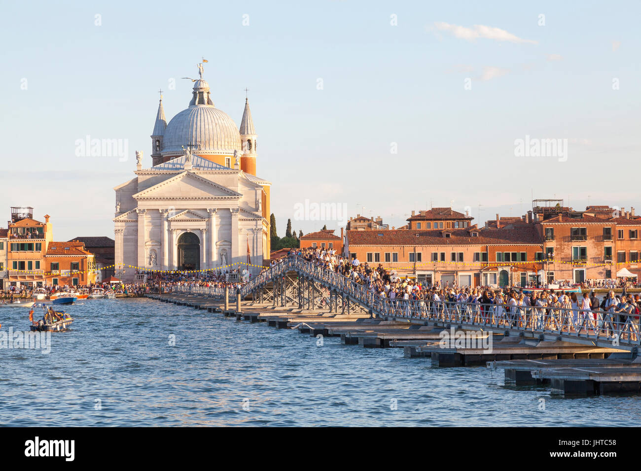 Venezia, Italia. Il 15 luglio 2017. 15 luglio 2017 Venezia, Italia. La gente sul ponte votivo sul Canale della Giudecca durante la Festa de la Festa del Redentore al tramonto. La Chiesa del Redentore è stata costruita in onore di Cristo Redentore in ritorno per far finire la pestilenza del 1575 al 1577 in cui oltre 50000 persone, quasi un terzo della popolazione, morì. La peste è stata dichiarata conclusa il 13 luglio 1577 e a questo giorno Venezia celebra questo evento ogni terza domenica del mese di luglio con la Festa de la Festa del Redentore. Credito: Maria Clarke/Alamy Live News Foto Stock