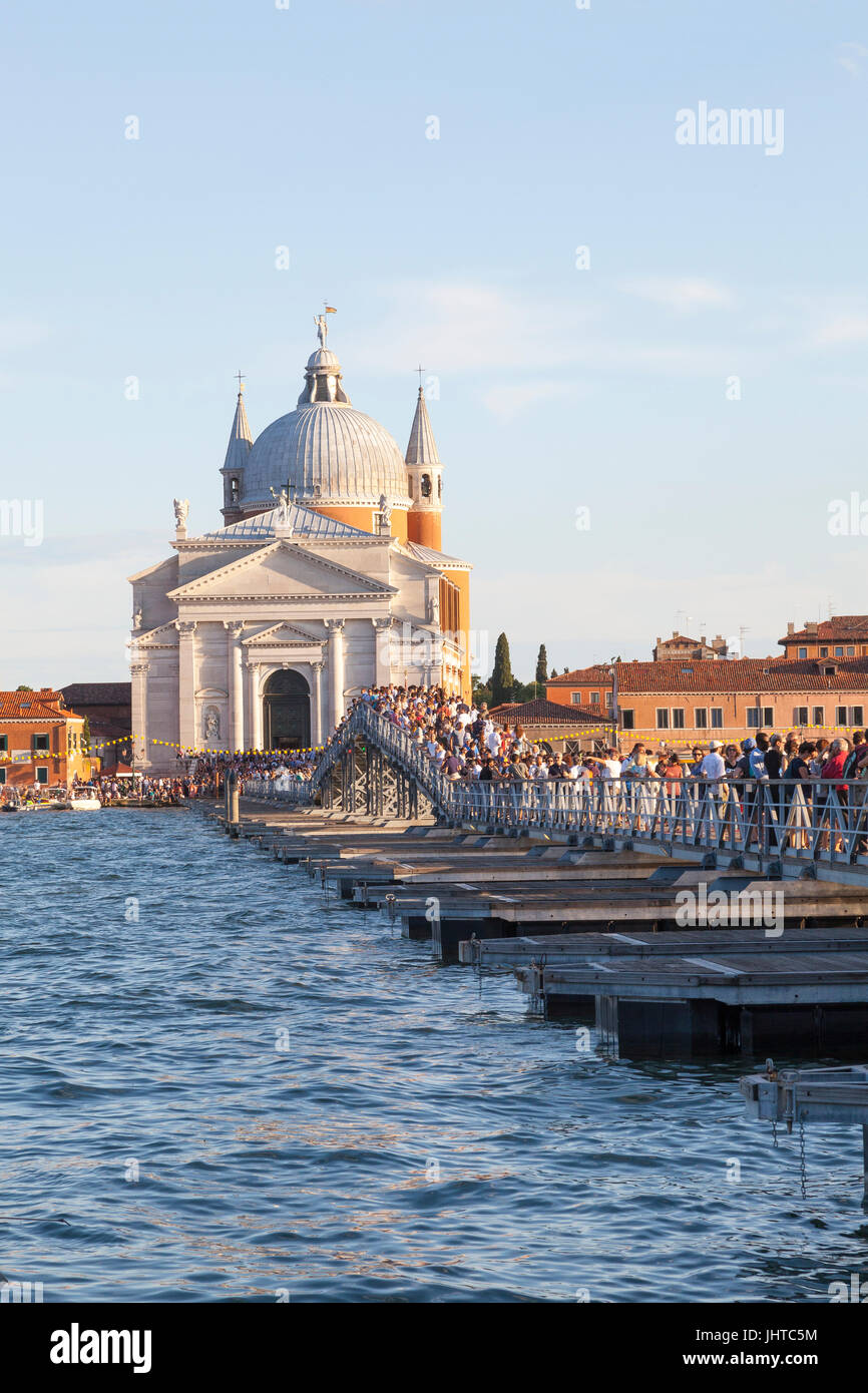 Venezia, Italia. Il 15 luglio 2017. 15 luglio Venezia, Italia. Le persone che attraversano il ponte votivo alla Chiesa del Redentore al tramonto che è stata costruita in onore di Cristo Redentore in ritorno per far finire la pestilenza del 1575 al 1577 in cui oltre 50000 persone, quasi un terzo della popolazione, morì. La peste è stata dichiarata conclusa il 13 luglio 1577 e a questo giorno Venezia celebra questo evento ogni terza domenica del mese di luglio con la Festa de la Festa del Redentore. Credito: Maria Clarke/Alamy Live News Foto Stock