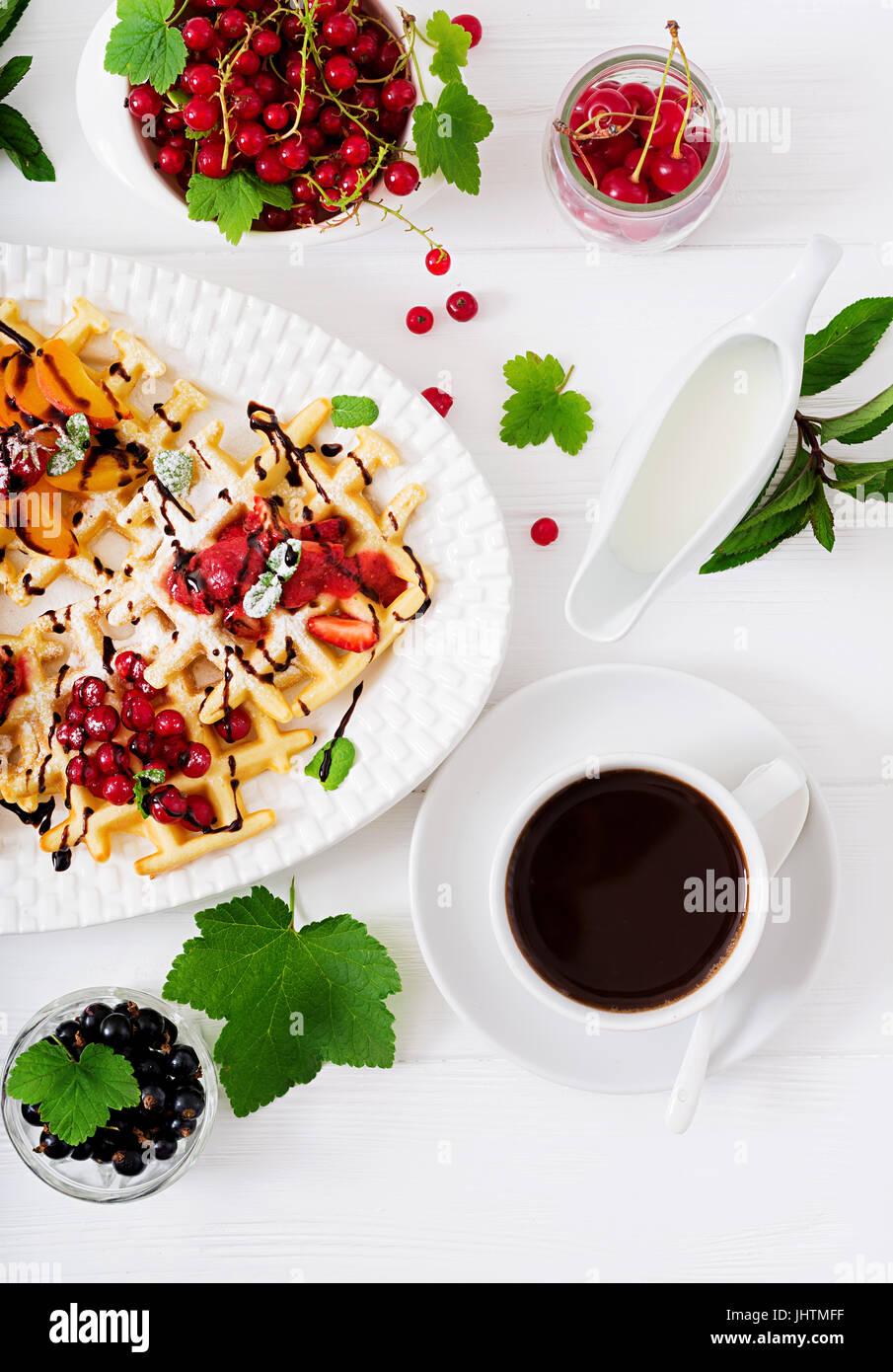 Varietà di cialde belghe con frutti di bosco, cioccolato e sciroppo. Foto Stock