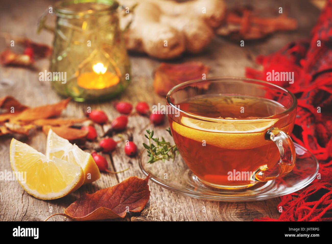 In autunno il tè con zenzero, limone, timo, rosa selvatica sul vecchio sfondo di legno (tonificante) Foto Stock