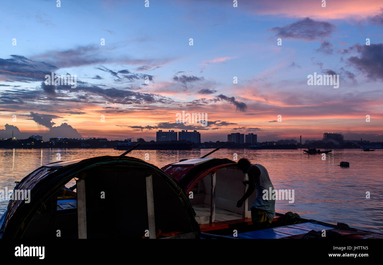 Silhouette di Vidyasagar Setu ponte al crepuscolo con una barca di legno sul fiume Hoogly. Foto Stock