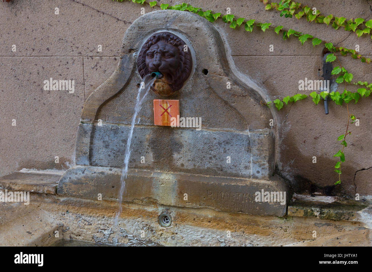 Sorgente Antica fontana in Rue de Porche, Grimaud, Francia Foto Stock