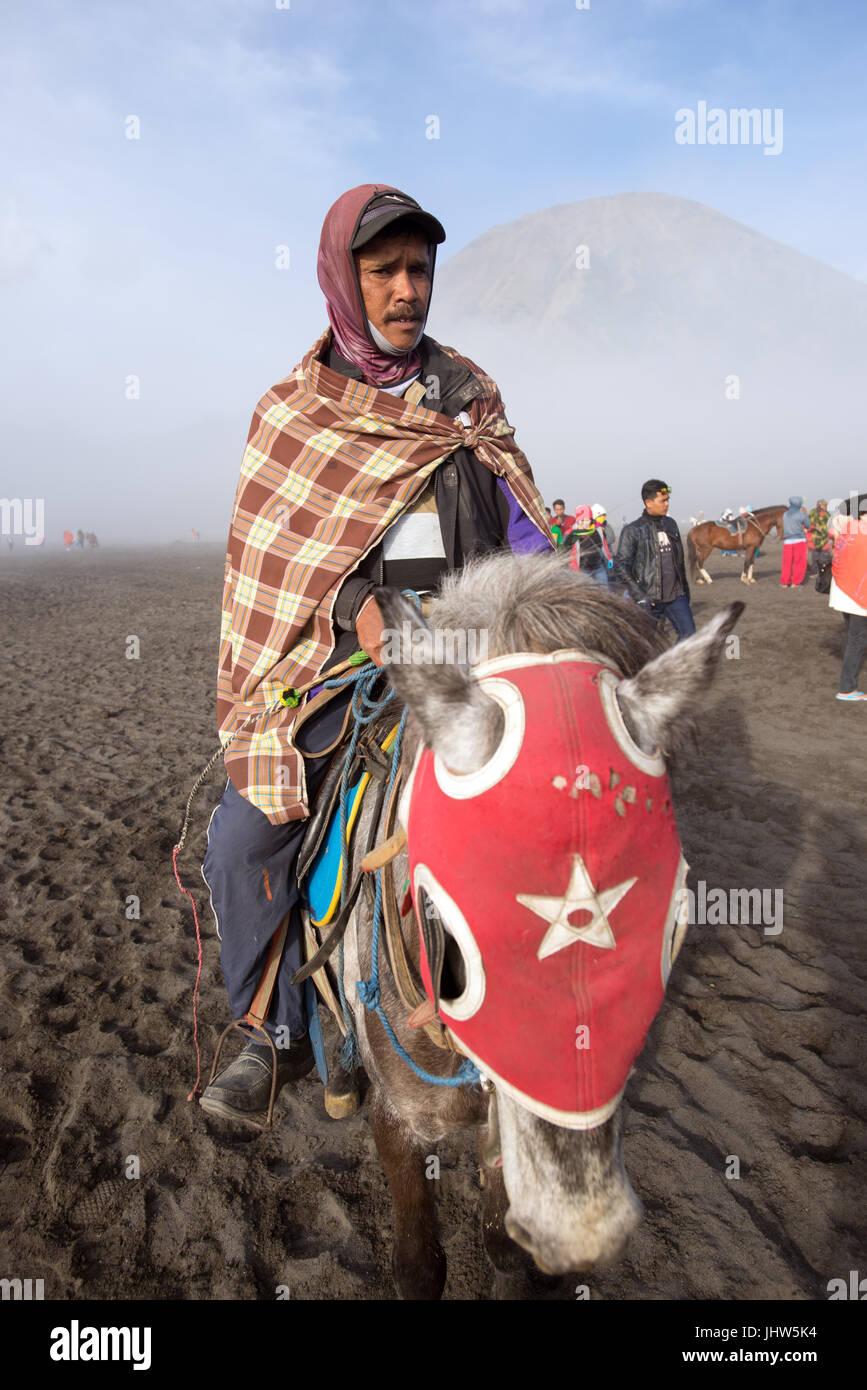 Gli indonesiani a cavallo nel mare di sabbia in Monte Bromo East Java Indonesia. Foto Stock
