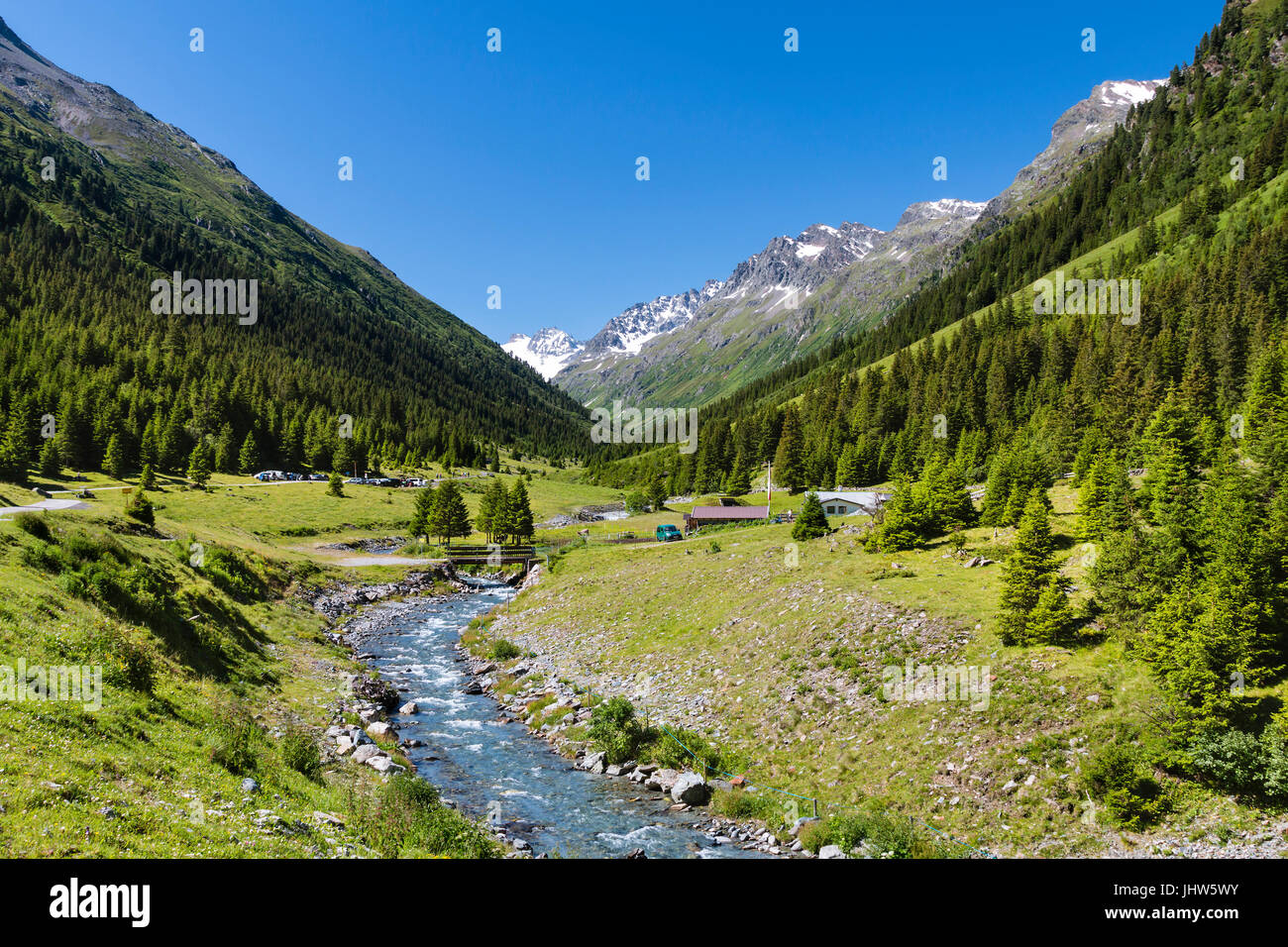 Menta Alm nella valle Jamtal con prati verdi e un fiume di montagna in una giornata di sole nei pressi di Galtur, Austria. Foto Stock