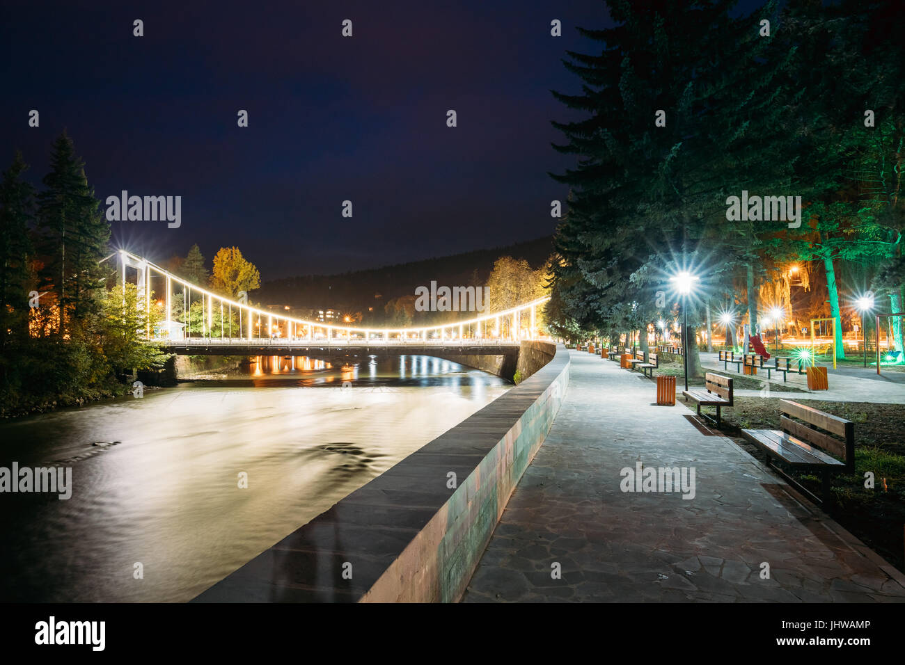 Borjomi, Samtskhe-Javakheti, Georgia. Vista notturna del ponte di bellezza sul fiume Kura passando attraverso la città. Serata di illuminazione notturna. Lunga esposizione. Foto Stock