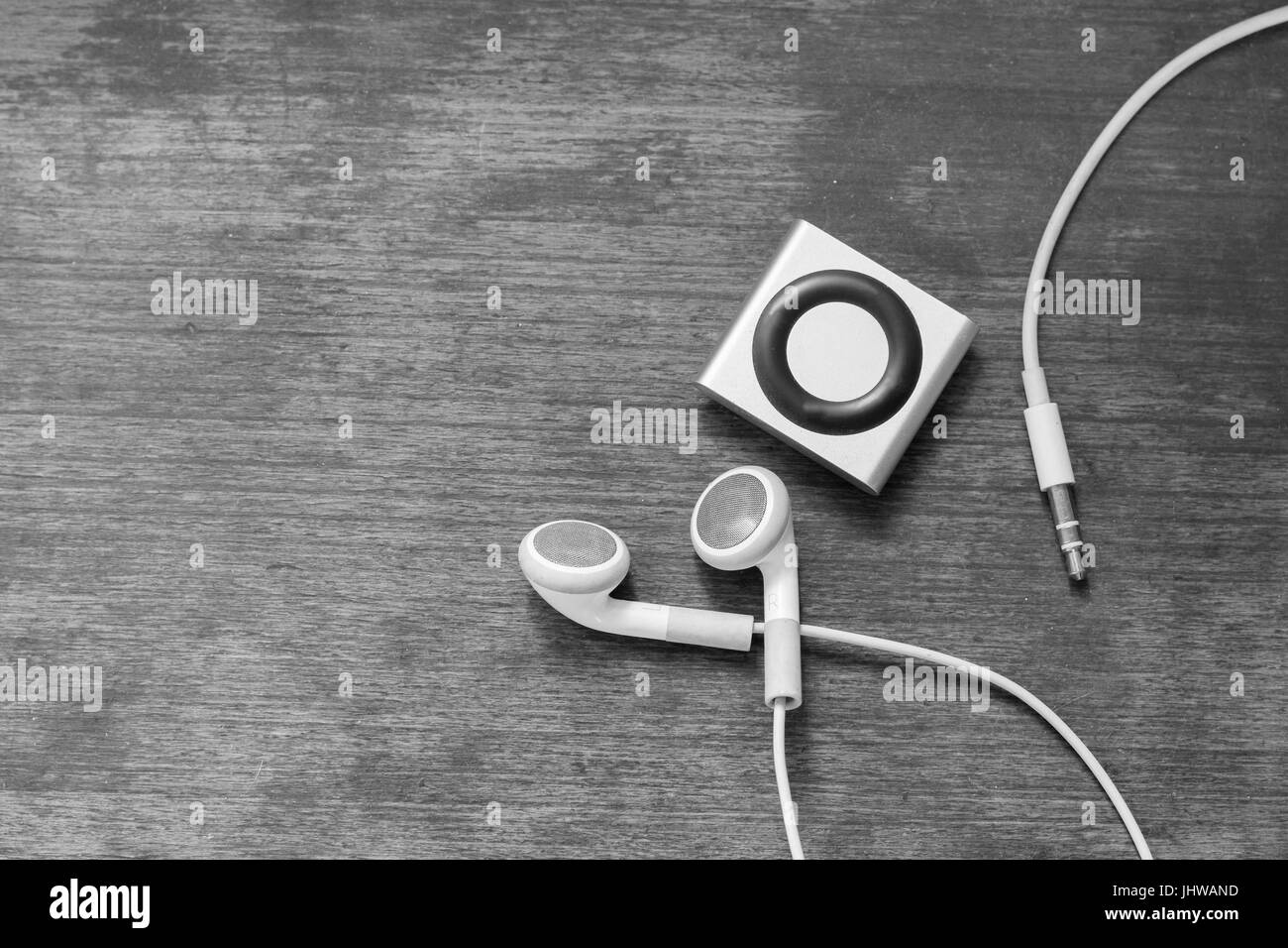 Sullo sfondo di un lettore digitale di musica con auricolari sdraiato sul pavimento in legno, il concetto di musica e stile di vita creativa, teens Foto Stock
