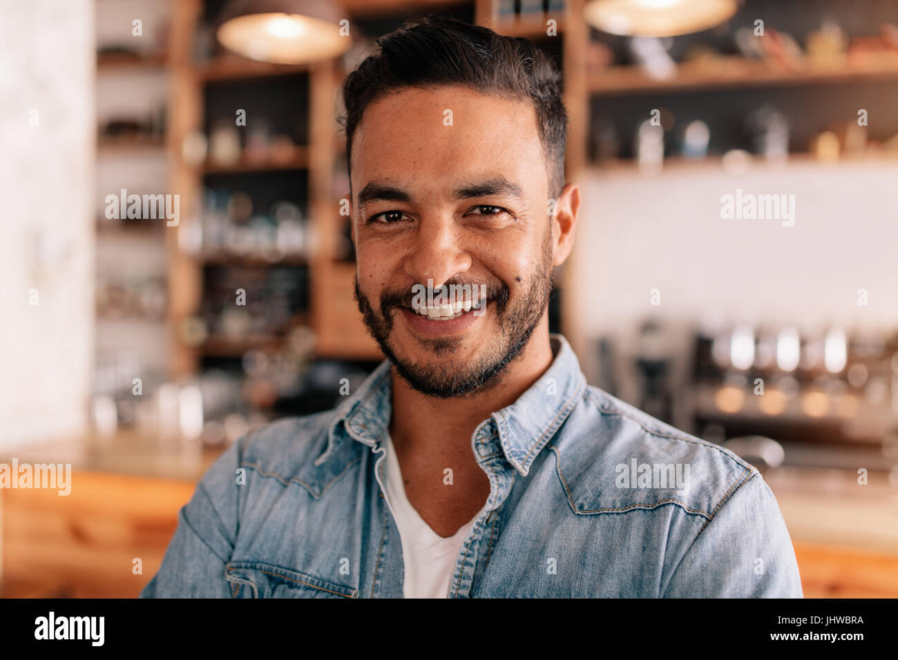 Close up ritratto del bel giovane uomo in piedi in una caffetteria. Sorridente giovane maschio caucasico in una caffetteria. Foto Stock