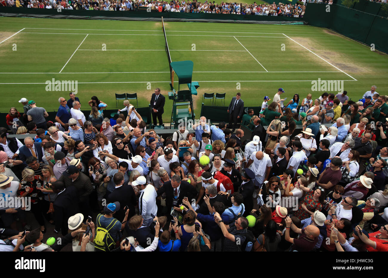 Roger Federer fa il suo modo attraverso una folla di spettatori a seguito di una sessione di formazione sulla giornata tredici dei campionati di Wimbledon al All England Lawn Tennis e Croquet Club, Wimbledon. Foto Stock