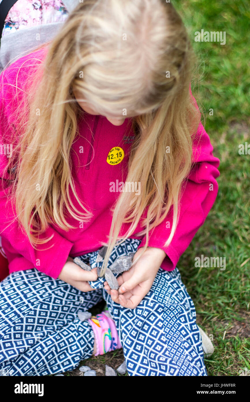 Ragazza bambino kid raccogliere pietre e studiandoli Foto Stock