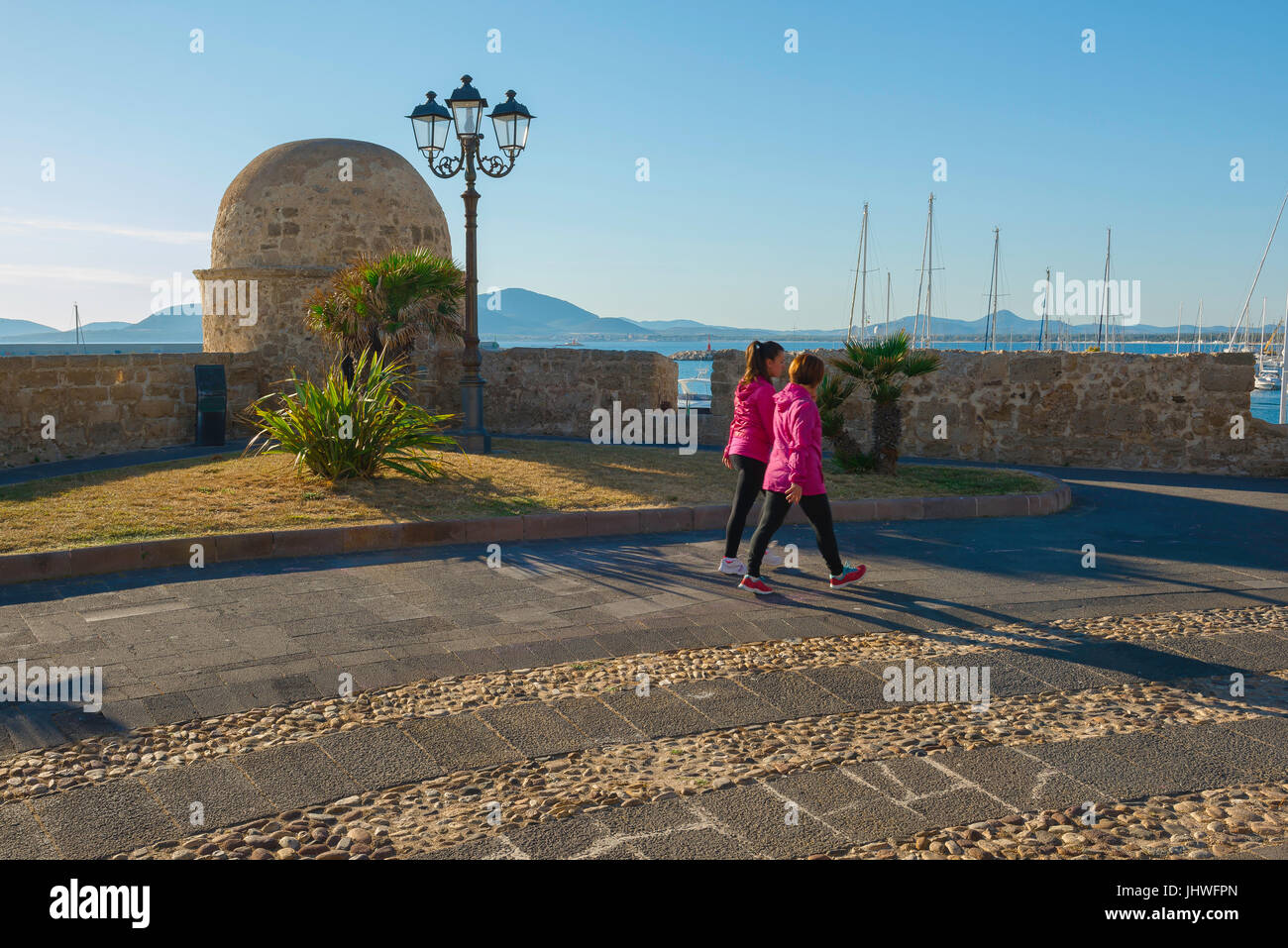 Alghero Sardegna, in una serata estiva di due giovani donne passeggiando lungo la promenade situato lungo i Bastioni Marco Polo di Alghero. Foto Stock