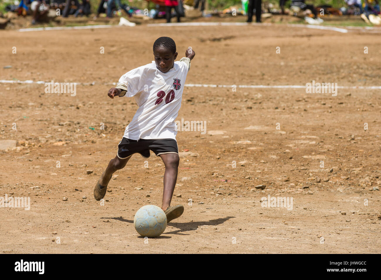 Bambini da Kibera Slum giocando a calcio su un passo di polverosi, Nairobi, Kenia Foto Stock
