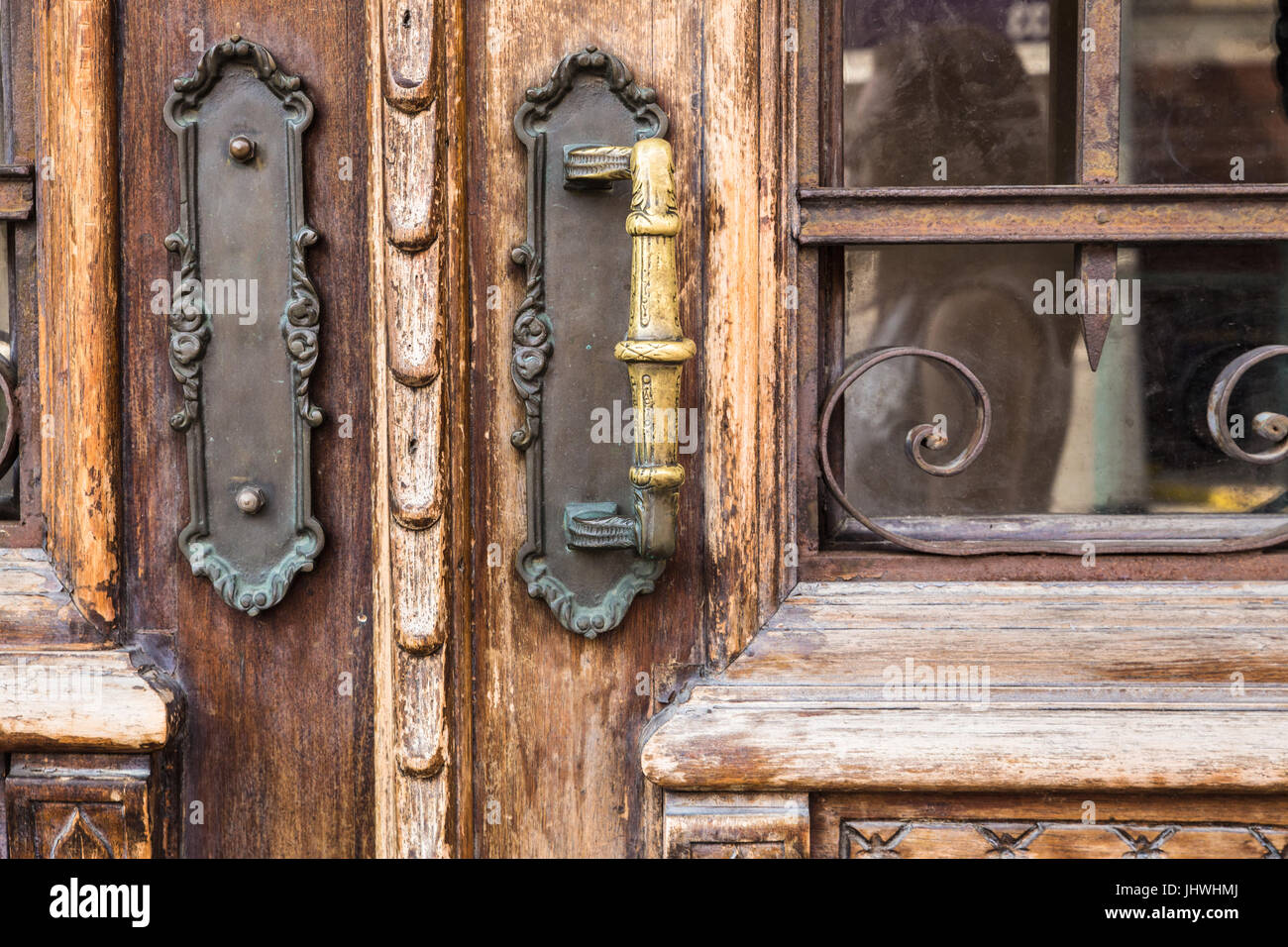 Primo piano di legno vecchio porta esterna con maniglie in ottone Foto Stock