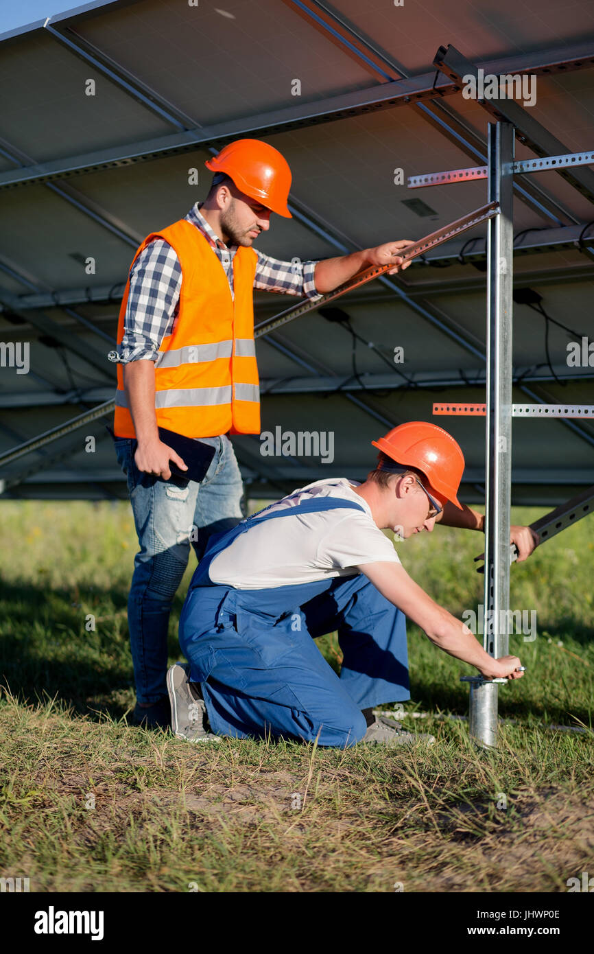 Costruttori di installare il telaio con pannelli solari sul palo elicoidale. Foto Stock