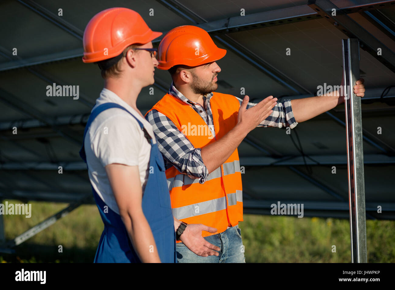 Lavoratori l'installazione di pannelli fotovoltaici a energia solare stazione. Foto Stock
