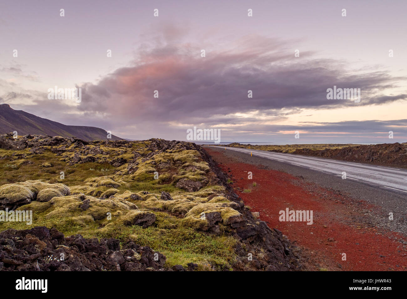 Strada desolata andando attraverso il paesaggio vulcanico in Islanda Foto Stock