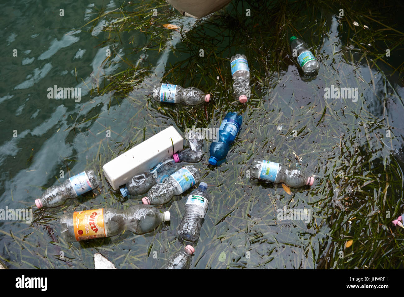 Le bottiglie di plastica galleggianti in acqua. Venezia. Italia Foto Stock