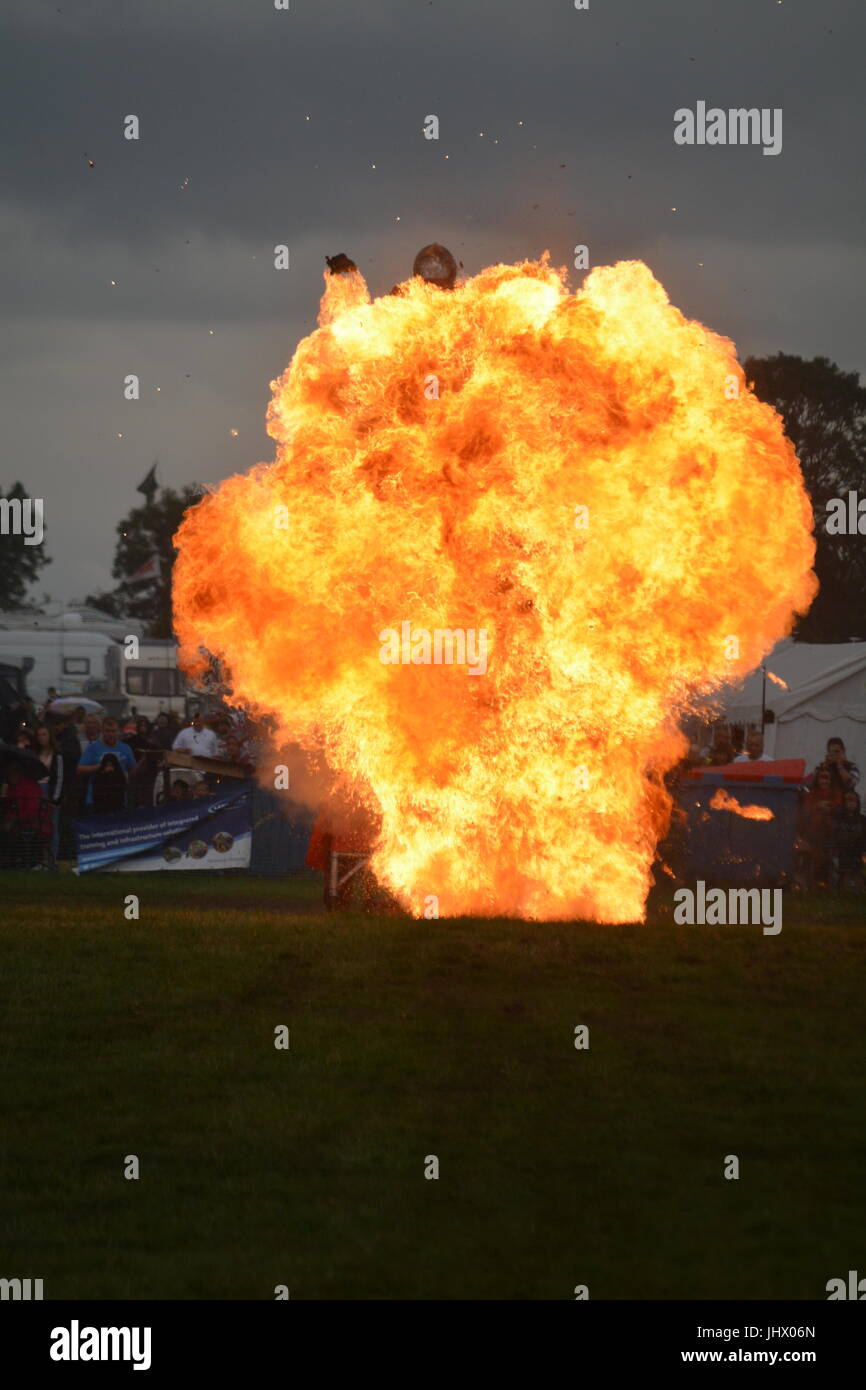 Motociclista acrobatico jumping mediante esplosione di fiamme Foto Stock