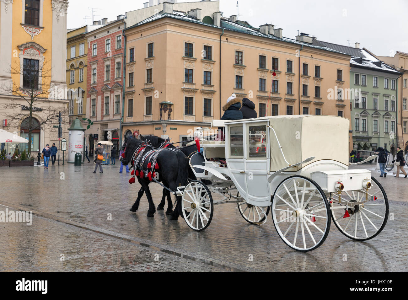 Cracovia in Polonia - 12 gennaio 2017: la gente non riconosciuto a piedi lungo il cavallo bianco carrello sulla piazza principale del mercato nella città vecchia. Cracovia è la seconda più grande Foto Stock