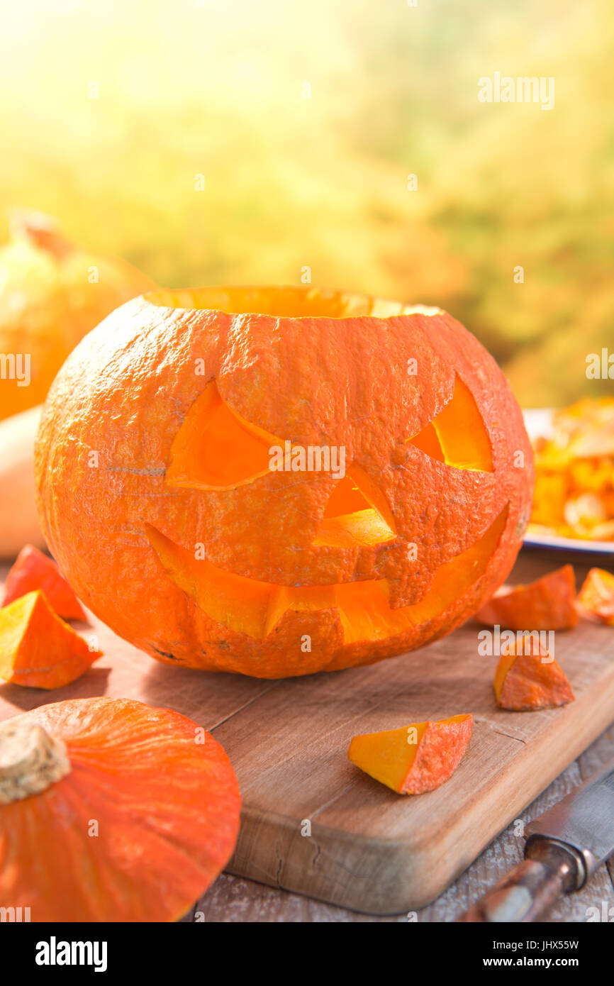 Il carving un Jack O'Lanterna su un rustico tavolo esterno in autunno. Foto Stock
