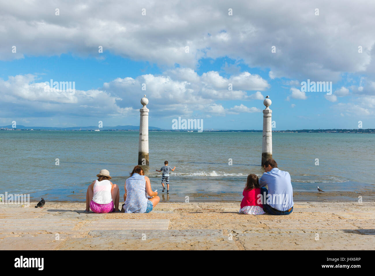 Famiglia al mare, in un pomeriggio d'estate una famiglia si rilassa in Cais das Colunas lungo il corso del fiume Tago a Lisbona, Portogallo. Foto Stock