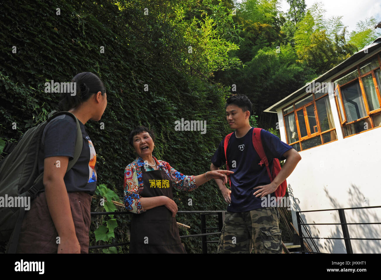 (170717) -- DEQING, luglio 17, 2017 (Xinhua) -- Cao Shuiying (C) introduce punti panoramici vicino ai turisti a 'Jianqi Inn' nella Contea di Deqing, est della Cina di Provincia dello Zhejiang, 16 luglio 2017. Situato sul Piemonte di Mogan in montagna Deqing contea di Zhejiang, 'Jianqi Inn' è venuto per il periodo più intenso per un anno. Cao Shuiying, che una volta era un contadino, iniziato il inn con la sua famiglia lo scorso luglio come il programma di costruzione di una bella campagna nel Zhejiang ha motivato lo sviluppo del turismo locale e homestay economia. Il suo 12-letto inn ha realizzato un profitto di oltre 500.000 yuan (circa 73,866 U.S. d Foto Stock