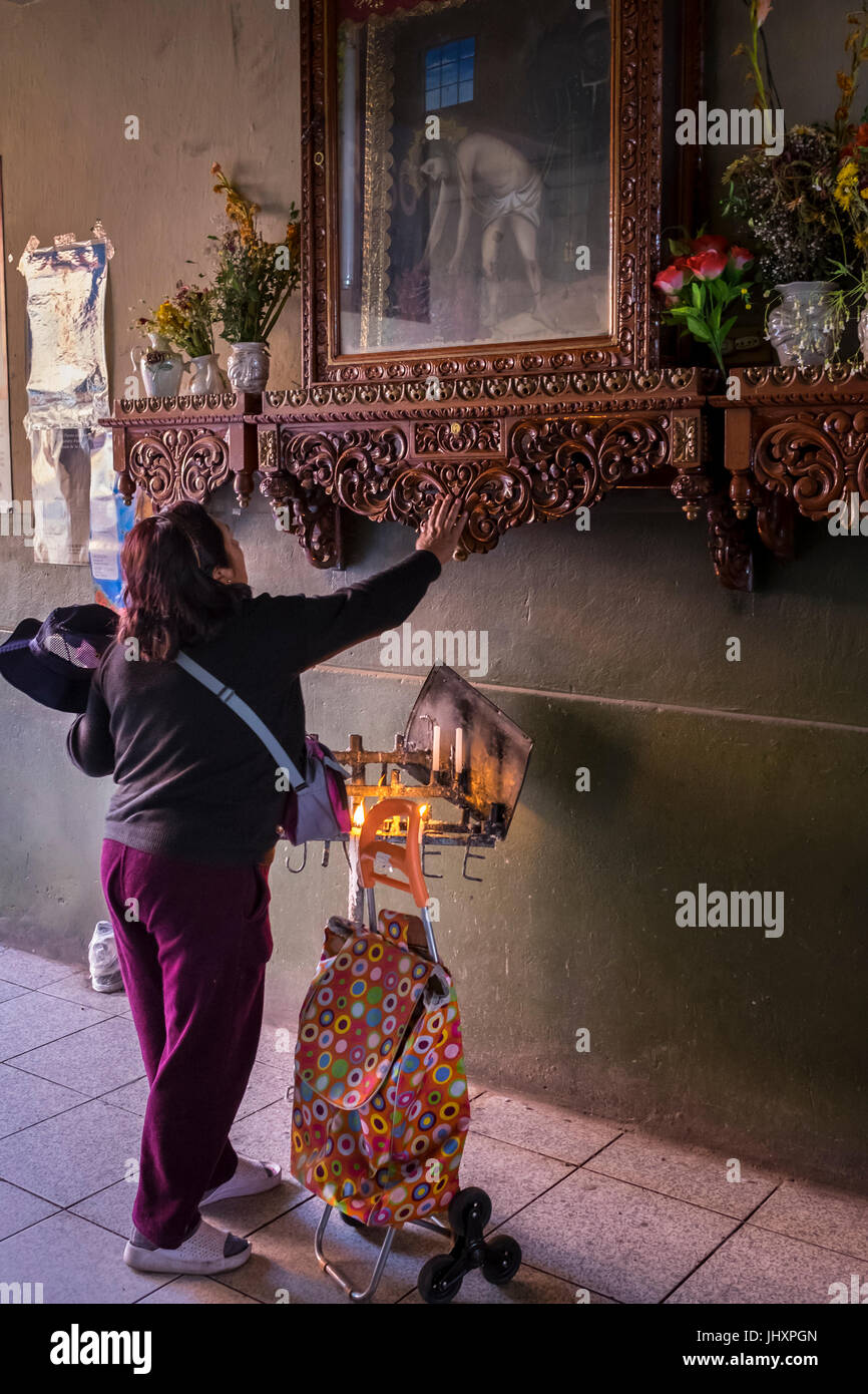 AREQUIPA, Perù - circa aprile 2014: Donna Peruviana adorare in corrispondenza di uno degli ingressi del San Camilo nel mercato. Arequipa è la seconda città del Perù da Foto Stock