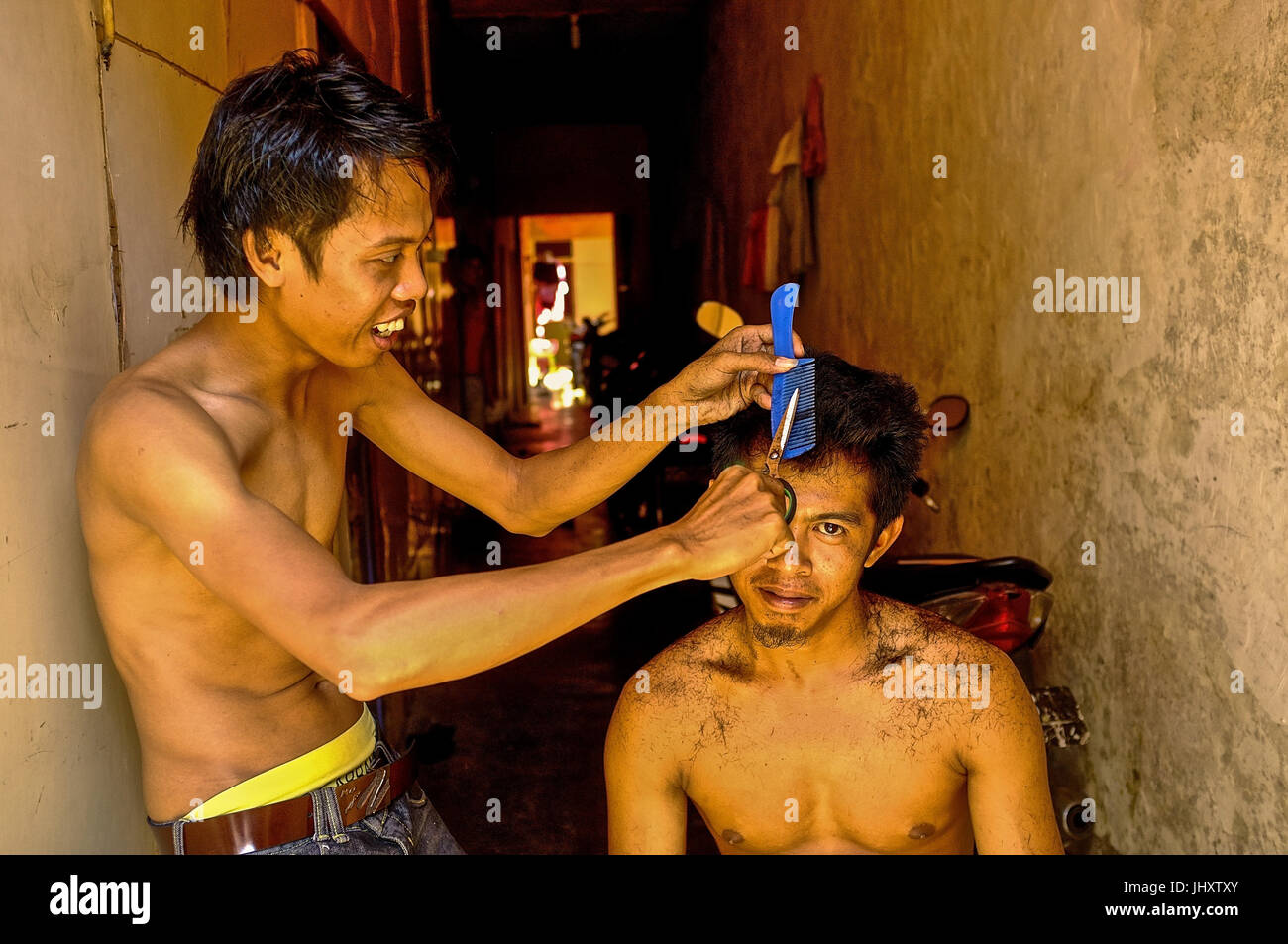 Un giovane indonesiano uomo riceve il suo taglio di capelli in Makassar, Sulawesi meridionale, Indonesia Foto Stock